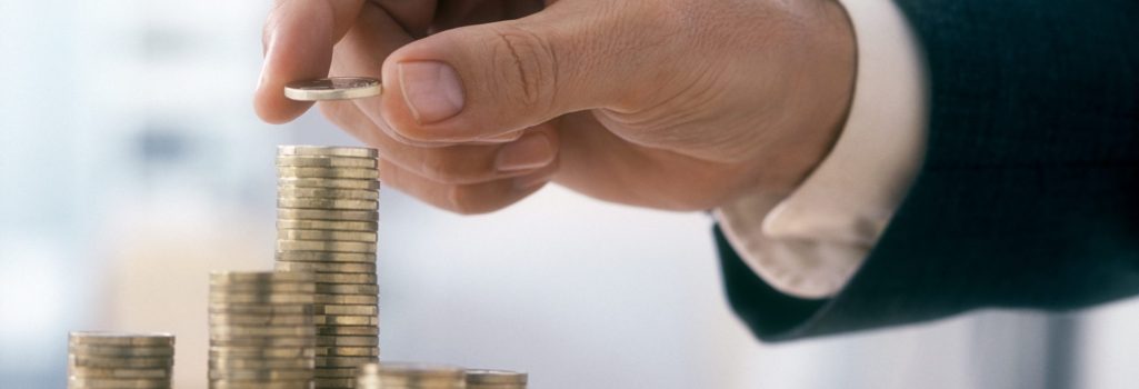 Hand of a mid adult man, wearing a siut, is stacking Euro coins. (2XL-File)